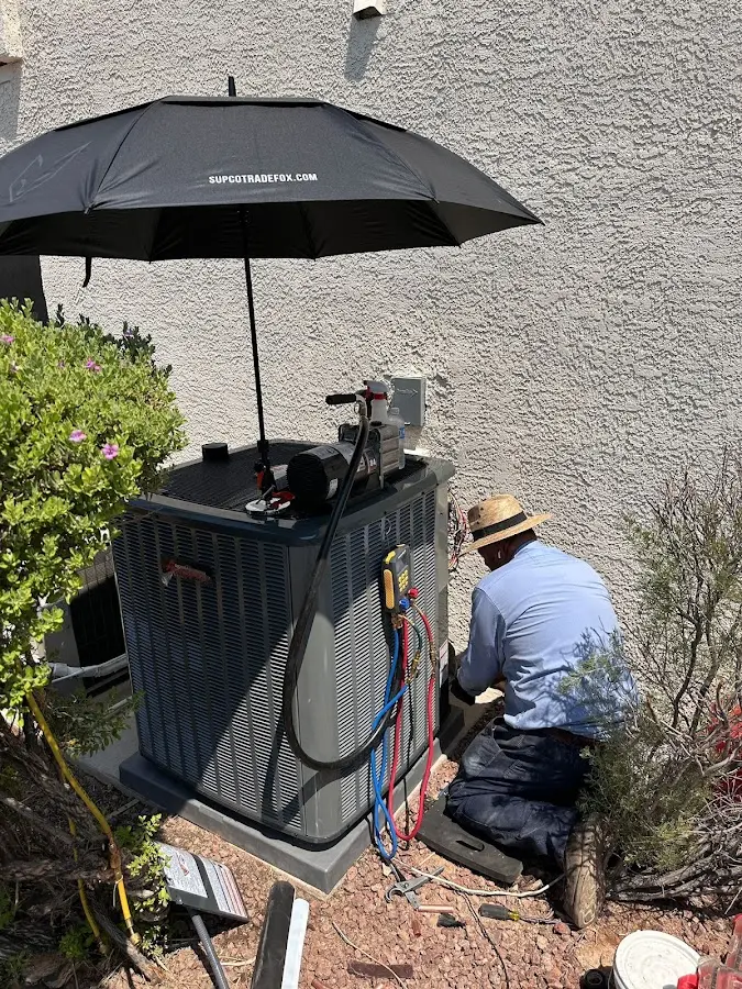 HVAC technician performing outdoor AC maintenance in Valley