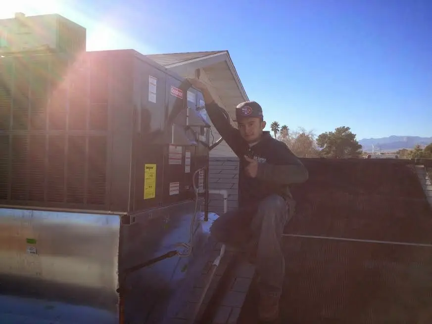 HVAC technician performing Air Duct Repair on a rooftop unit in Valley